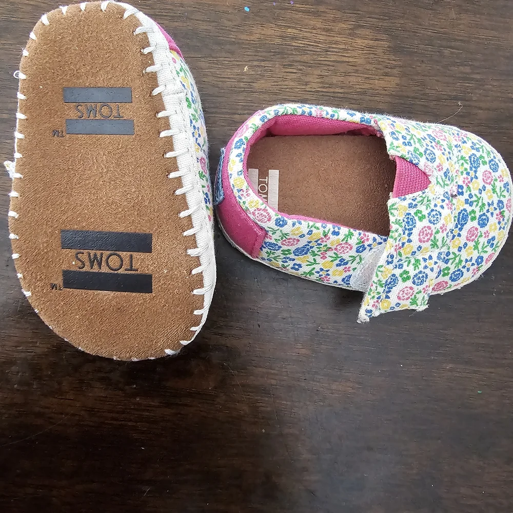 3 pairs of baby/girl shoes—soft, floral, and glittery—in various styles.